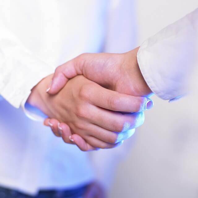 Imagen de dos personas dándose la mano, como ejercicio de confianza.